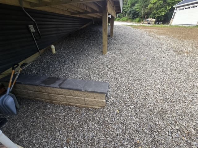 Under-deck crushed gravel area with decorative stone border step