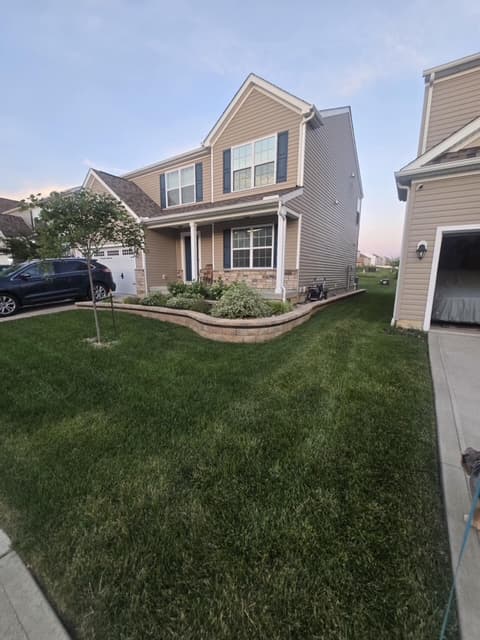 Manicured front yard with curved stone retaining wall and foundation plantings