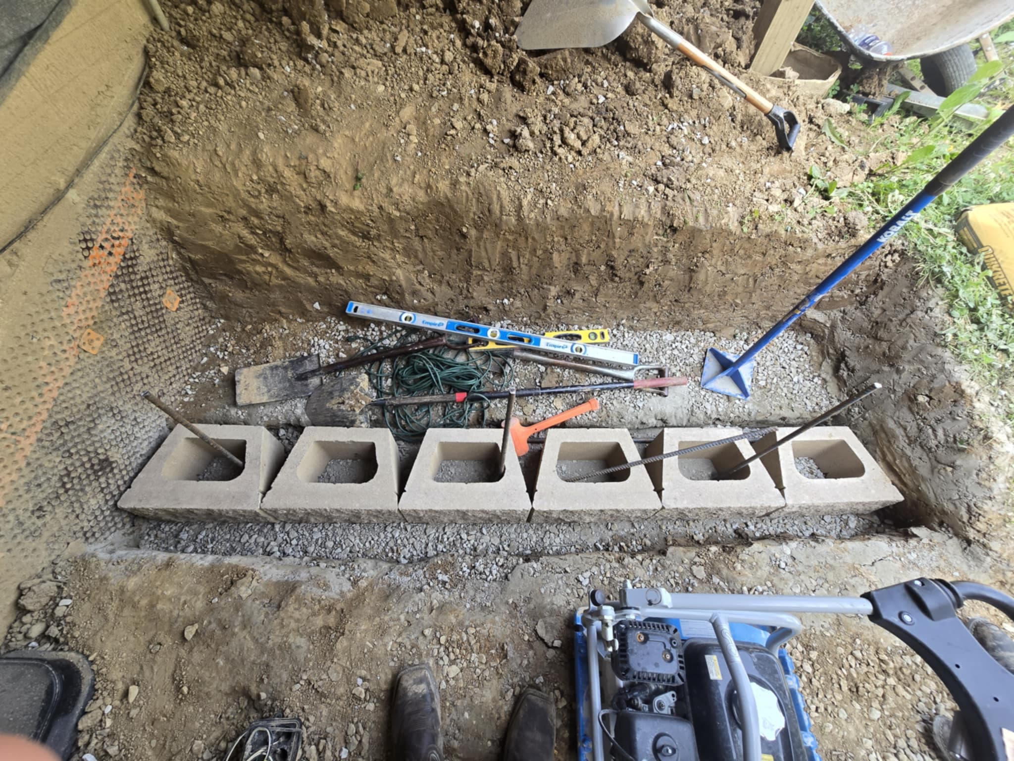 Concrete block foundation installation for retaining wall