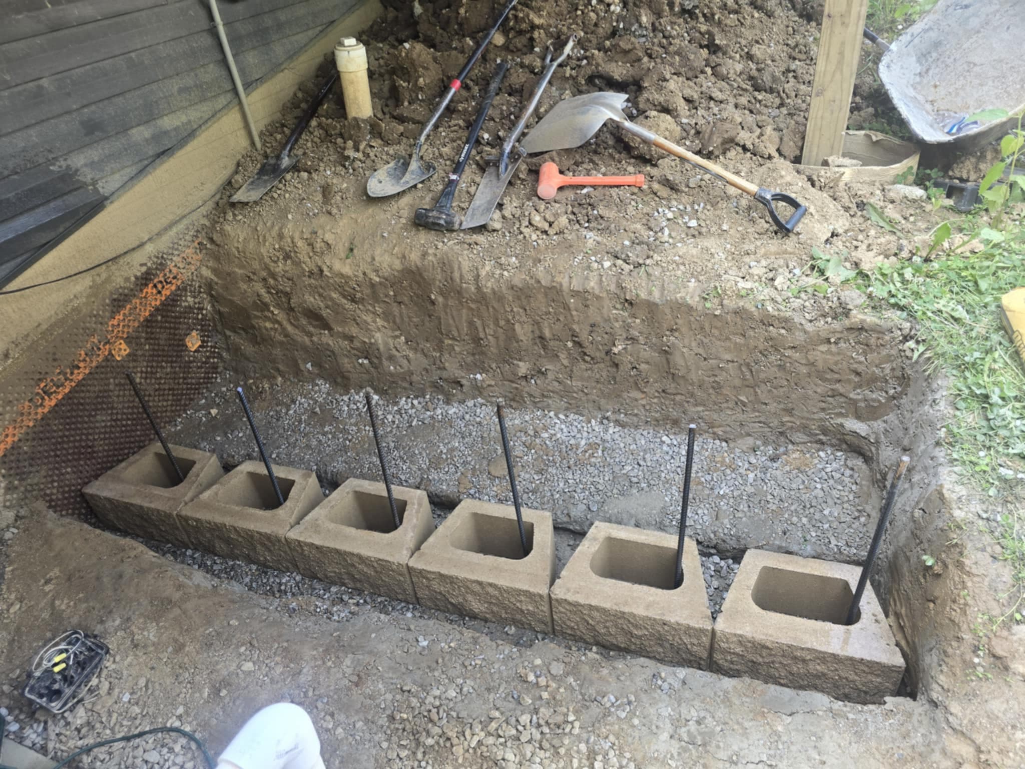 Concrete block retaining wall foundation with rebar reinforcement