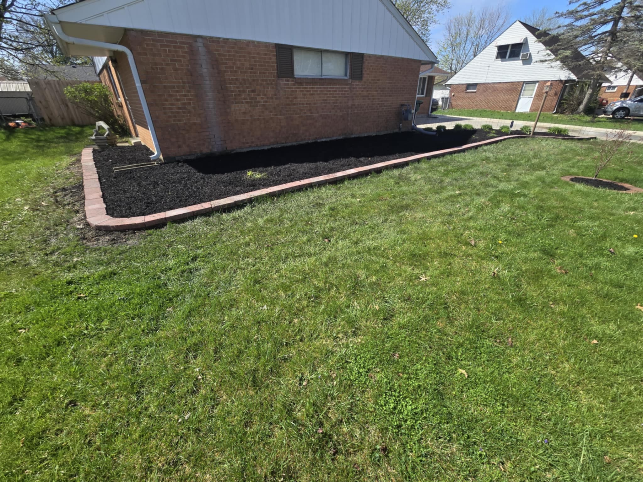 Wide view of red brick border foundation bed with fresh mulch